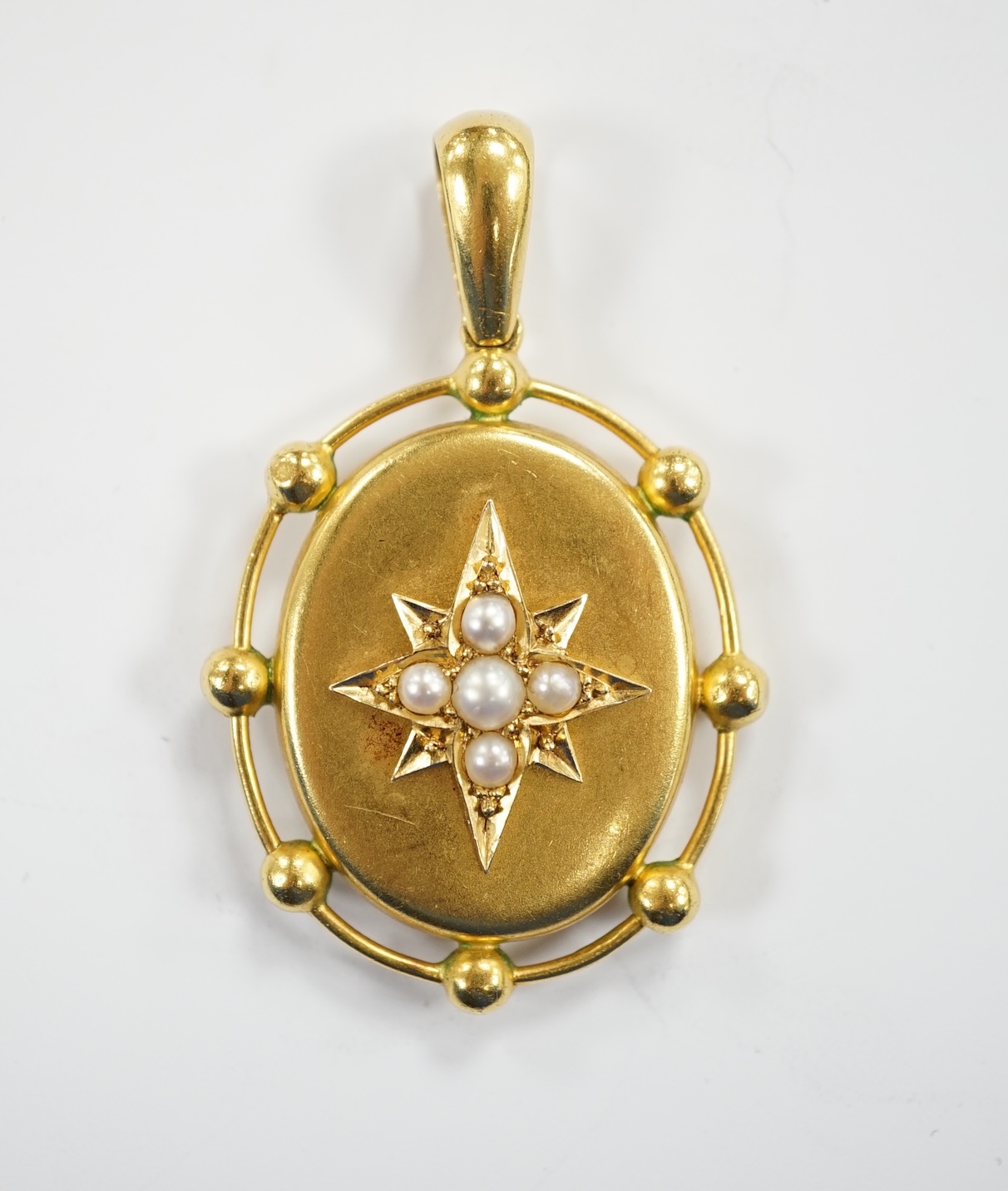 A Victorian yellow metal and split pearl set oval pendant, the glazed back with painted monogram beneath, EC, overall 48mm, gross weight 9.2 grams.